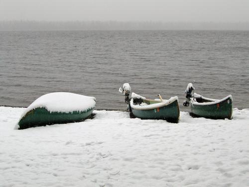 snow-covered canoes in May on the Allagash Wilderness Waterway in northern Maine