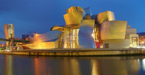 a just-after-dark panoramic view of the Guggenheim Museum at Bilbao in Spain