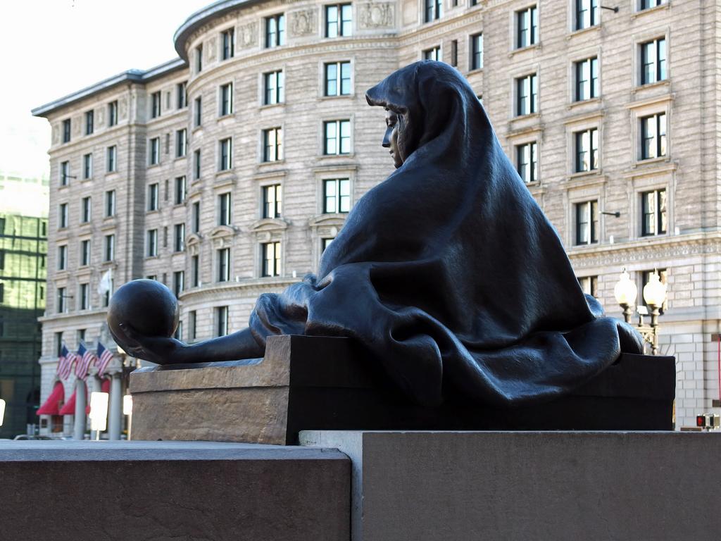 a statue (representing science) holding our Earth in her hand at the entrance to the Boston Public Library