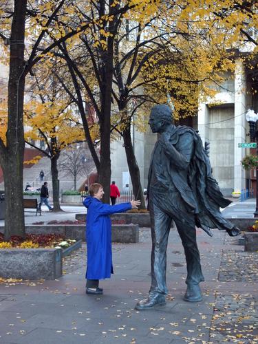 a visitor greets a statue near Quincy Market in Boston