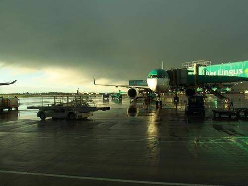 Aer Lingus airplane at the Dublin Airport in Ireland as light breaks into a stormy sky