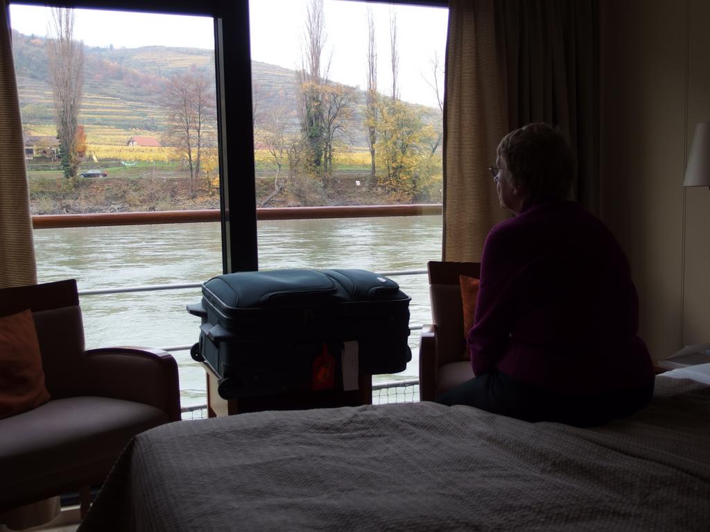 Betty Lou watches the passing view of Wachau Valley of Austria on the Danube River from our stateroom on the Viking Legend cruise ship