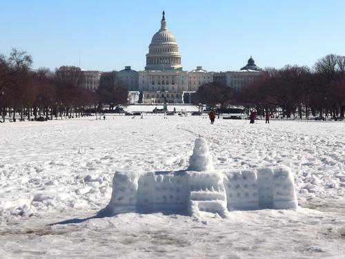 winter view of the Capitol Building with a snow replica in the foreground at the National Mall in Washington DC