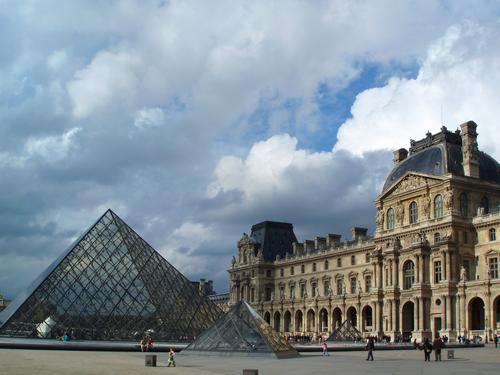 glass-pyramid entrance and classic-style stone buildings of the Louvre in Paris, France