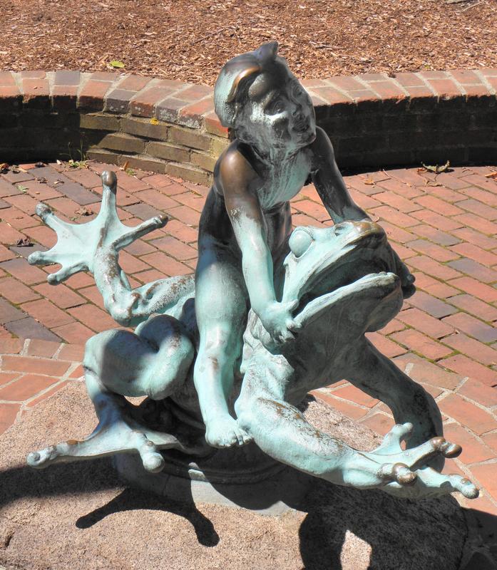statue of a boy riding bareback on a giant frog