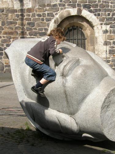boy climbing a statue at a park in west Germany