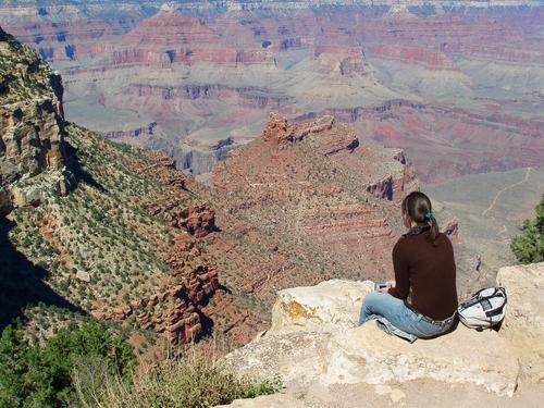 tourist taking in the view from the south rim of the Grand Canyon in Arizona