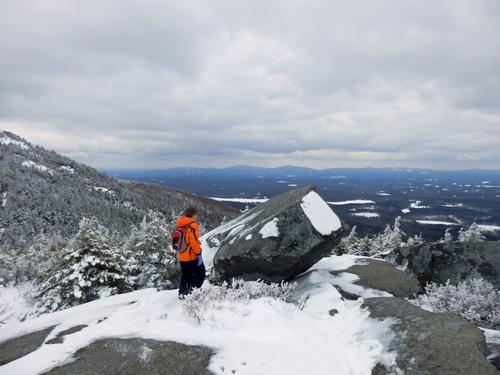 winter hiker atop Bald Rock on the shoulder of Mount Monadnock in New Hampshire