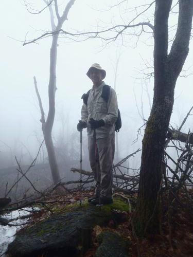 hiker on the foggy summit of Bald Sunapee mountain in New Hampshire