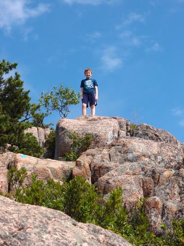 young hiker near the top of the Beehive Trail at Acadia National Park in Maine