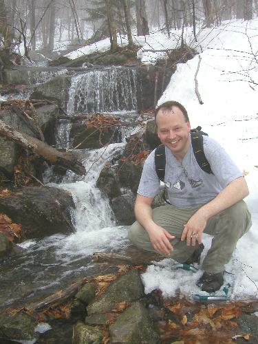 hiker on soggy wet trail to Belknap Mountain in New Hampshire