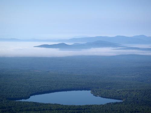 early-morning fog fills the valley making for a great undercast mountain view from the summit of Boundary Bald Mountain in Maine