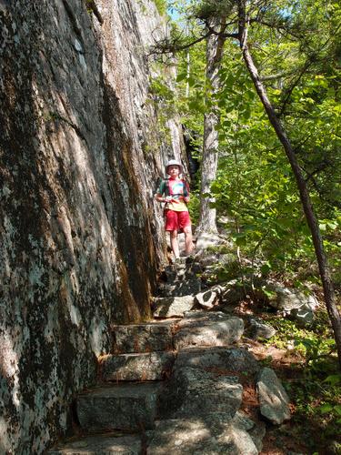 young hiker on the Ladder Trail to Dorr Mountain at Acadia National Park in Maine