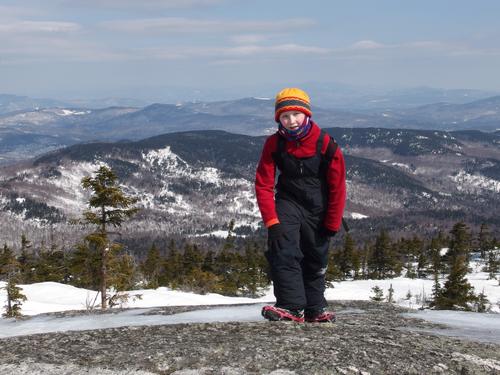 Carl approaches the summit of Mount Cardigan in New Hampshire with a neat mountain panorama behind him