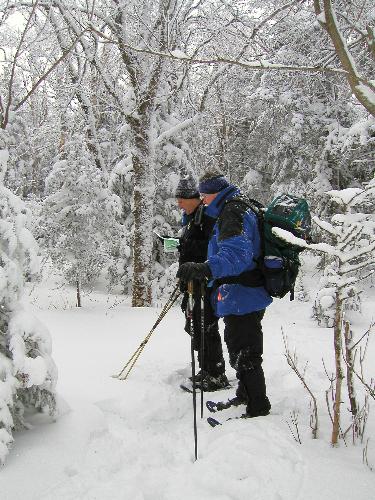 winter hikers check the trail map on Martha's Mile in New Hampshire