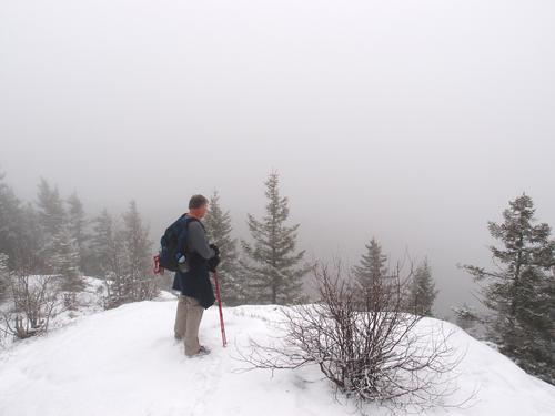 hiker in pea-soup weather at the summit of Mount Crosby in New Hampshire