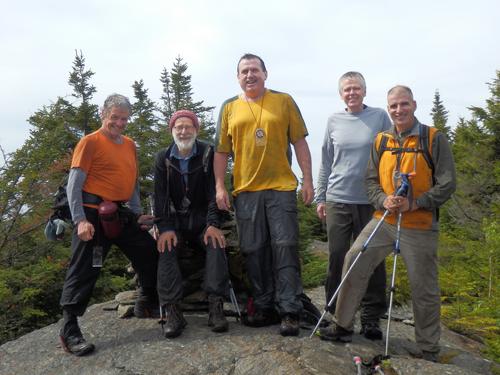 hikers at the summit cairn on Grantham Mountain in western New Hampshire