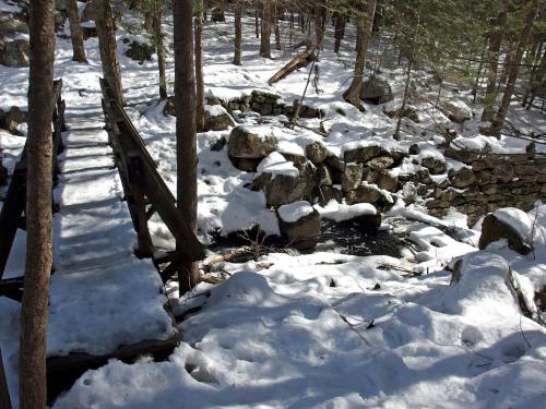footbridge and old mill site in February at Darby Brook Conservation Area in New Hampshire