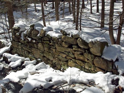 sluiceway stone wall in February at Darby Brook Conservation Area in New Hampshire