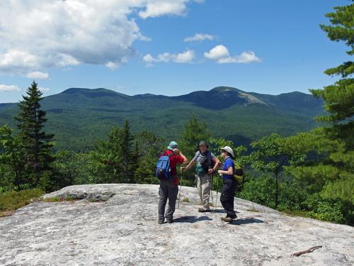 John, Dick and Elaine stand atop Little Deer Hill in Maine with a view of 
Eastman Mountain (left) and South Baldface (right) across Evans Notch in New Hampshire
