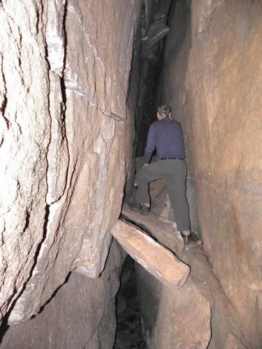 hiker entering the cave on Devils Den Mountain in New Hampshire