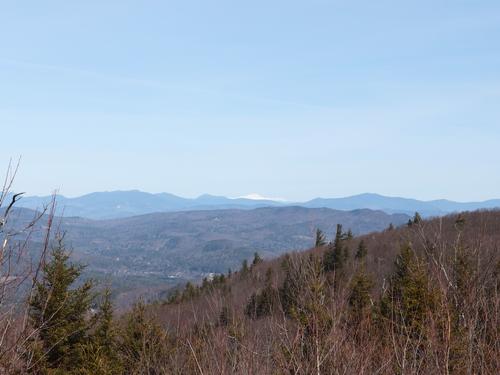 view in late March of the distant White Mountains from a clearing on the shoulder of Dickinson Hill in New Hampshire
