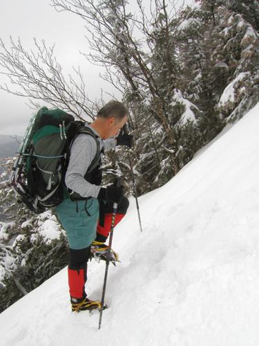 winter hiker ascending a steep snowy trail to Mount Osceola in New Hampshire