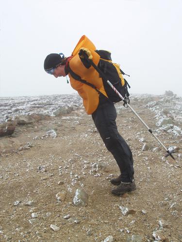 a hiker leans into the wind on Mount Eisenhower in New Hampshire