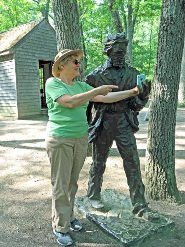 Andee shows Thoreau's statue her smartphone at Emerson-Thoreau Amble in Massachusetts