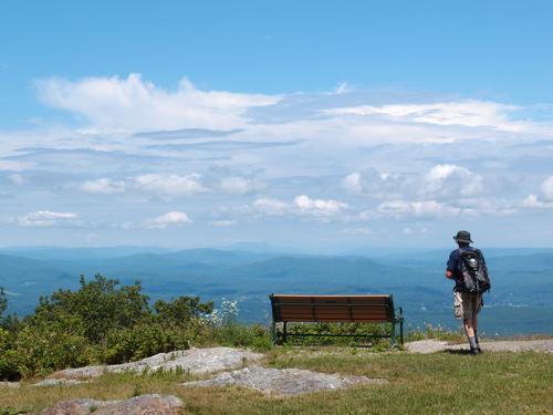 bench, hiker and easterly view from the near-summit lookout on Mount Everett in southwestern Massachusetts