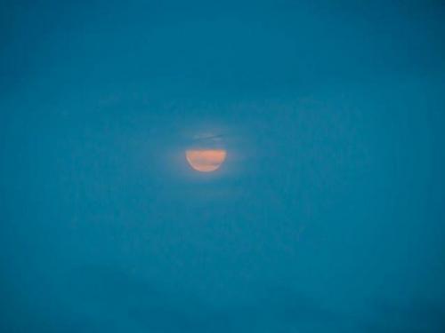 view of the shrouded full moon from the fire lookout tower atop Federal Hill in southern New Hampshire