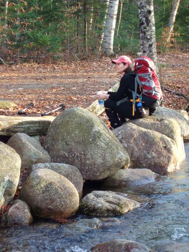 resting hiker at the junction of the Lincoln Woods and Osseo trails in New Hampshire