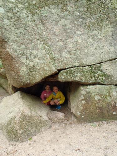 visitors under the Great Boulder at Flume Gorge in New Hampshire
