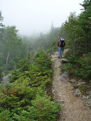 hiker in fog on the Mount Coe Trail in Maine