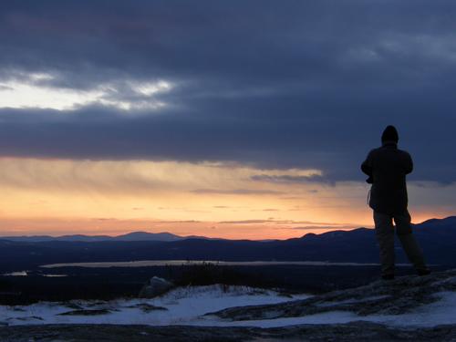 Jeremy enjoys December sunset atop Foss Mountain in way eastern New Hampshire