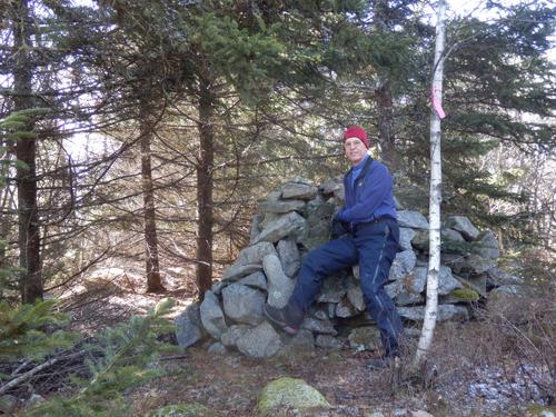 hiker at the cairn atop the South Peak of Gap Mountain in New Hampshire