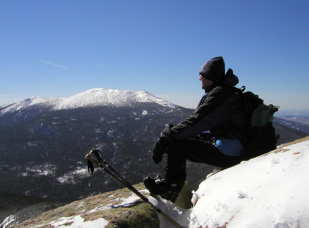 Tom takes in the winter view from atop Mount Garfield with Mount Lafayette in the background in the White Mountains of New Hampshire