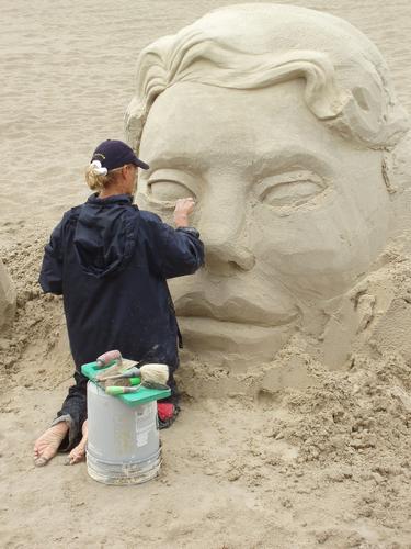 a professional artist works on her sand sculpture at Hampton Beach in New Hampshire