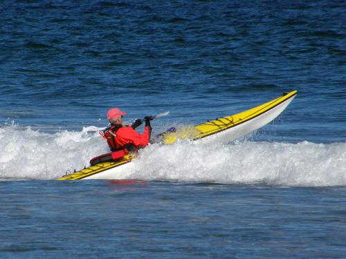a kayaker surfing at Hampton Beach in New Hampshire