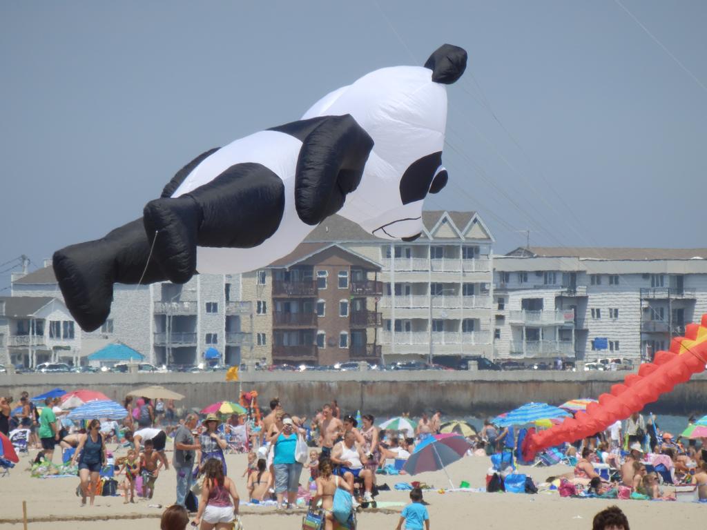 creative panda balloon-kite floats above a crowd of beachgoers at Hampton Beach in New Hampshire