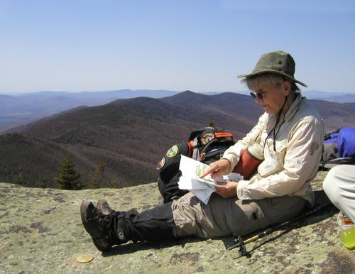 hiker on the summit and view from The Horn in New Hampshire