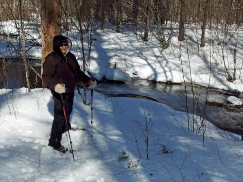 Andee in March beside Burnham Brook at Hutchins Forest in New Hampshire