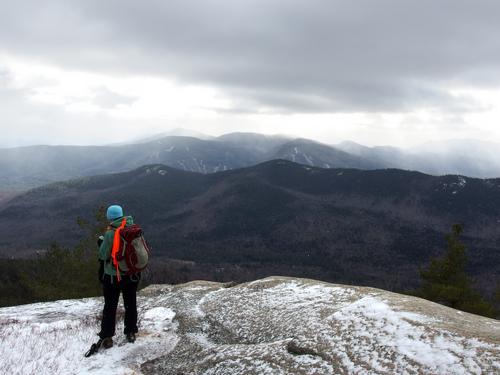 hiker and stormy view from the South Cliffs of Iron Mountain in New Hampshire