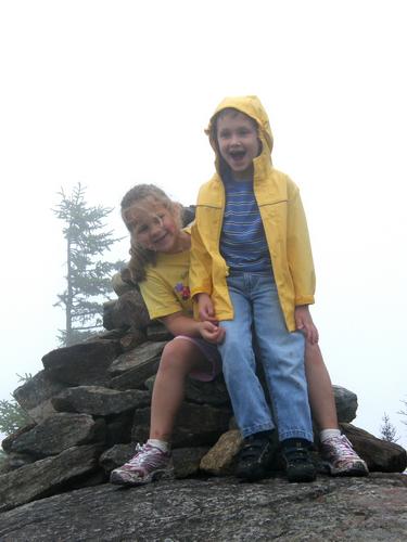 young hikers at the summit cairn on Mount Israel in New Hampshire