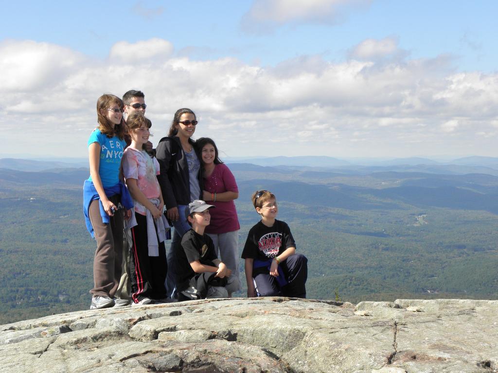 Wayne and Holly pose on the edge with their kids on Mount Kearsarge in New Hampshire