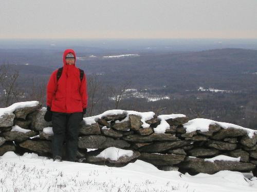 hiker and winter view from Kidder Mountain in New Hampshire
