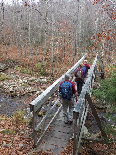 hikers crossing a foot bridge on the Bucklin Trail to Killington Peak in Vermont