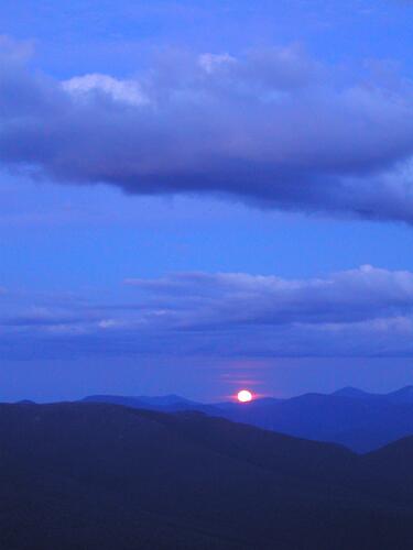vivid-blue moonrise caused by forest fire smoke as seen from North Kinsman Mountain in New Hampshire