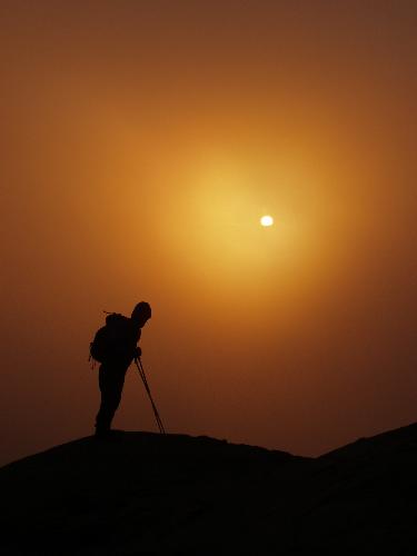 hiker and storm-obscured sun on Mount Lafayette in New Hampshire