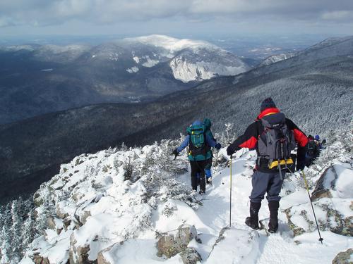 January hikers head down ridge toward Franconia Notch and Cannon Mountain from Mount Liberty in the White Mountains of New Hampshire